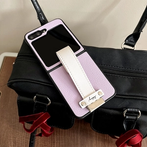 Macro detail of purple litchi leather texture and white hand strap with happy engraving