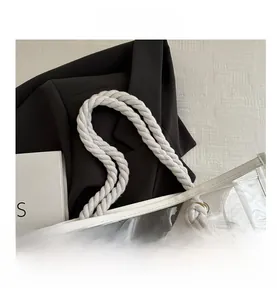Close-up of transparent PVC tote bag with white cotton rope handles and tassel details