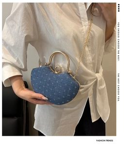 Detail of blue denim jacquard handbag with pearl clasp and golden chain strap