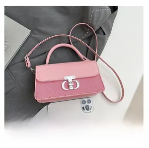 Pink leather handbag detail featuring striped fabric panels and a silver metal buckle closure
