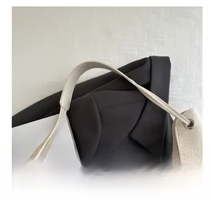 Détail du sac à main en cuir grainé beige avec œillets métalliques argentés élégants