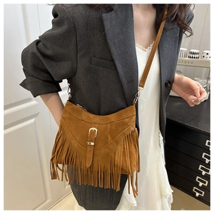 Brown suede tassel bag with vintage belt buckle detail and fringe shown on model