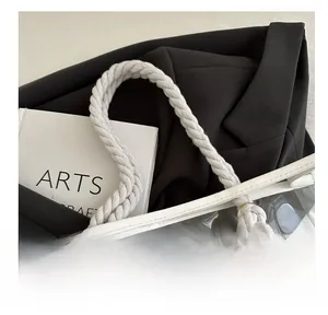 Detail of transparent PVC tote bag featuring white braided cotton rope knotted handles