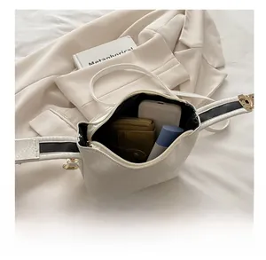 Interior view showing the capacity of a white faux leather pillow bag with metal zipper