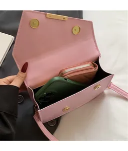 Sac bandoulière rose minimaliste avec boucles magnétiques et rangement intérieur spacieux