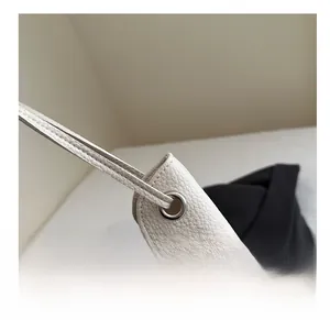 Détail du sac cabas en cuir grainé avec œillets métalliques et fine bandoulière