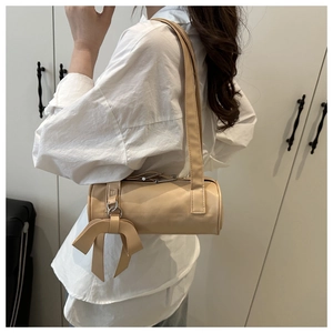 Dettaglio della borsa a cilindro beige con fiocco decorativo e pelle PU liscia di qualità