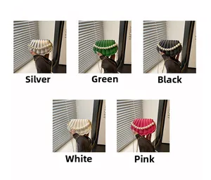 Mini shell-shaped crossbody bags in various colors featuring pearl handles and chain straps