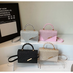 Détail de mini sacs en quatre couleurs avec rabats pailletés asymétriques et anses tressées