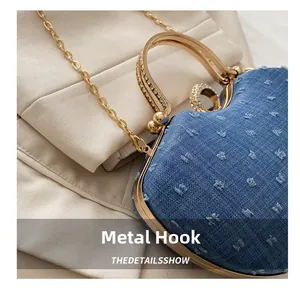 Detail of blue denim saddle bag featuring sparkling rhinestone hardware and golden chain
