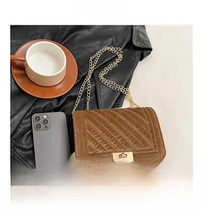 Detail of brown velvet shoulder bag with gold twist lock and quilted stitching
