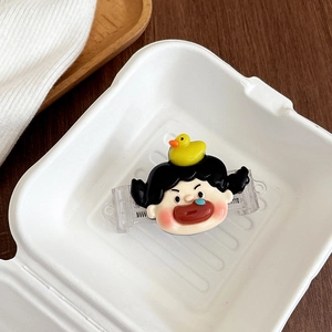 Nahaufnahme einer kreativen Cartoon-Mädchen-Haarspange mit kleiner Ente in Papierbox