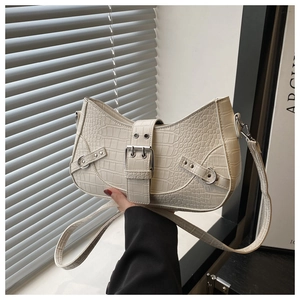 Detail of cream crocodile embossed hobo bag with silver buckle and metallic rivets