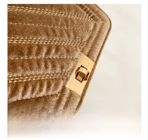 Macro detail of brown velvet handbag featuring V-quilted texture and gold rotary lock