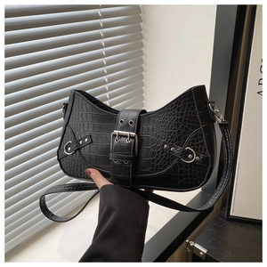 Detail of black crocodile texture PU leather shoulder bag with silver metal buckle and rivets