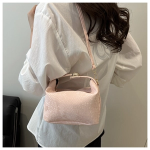 Detailed shot of pink faux snakeskin pillow bag featuring elegant gold metal hardware