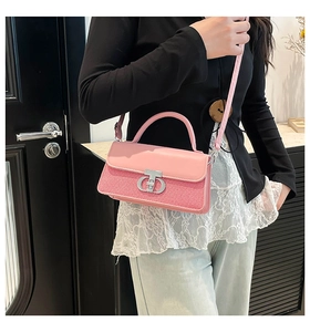 Detailed view of pink leather and woven fabric handbag featuring a metallic CD buckle
