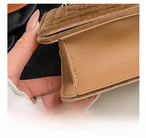Close-up of precise stitching and V-quilted velvet texture on a brown crossbody bag
