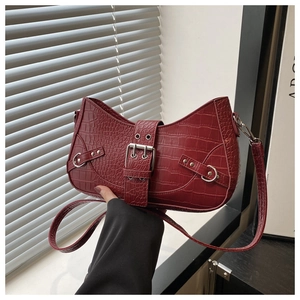 Close-up of crocodile pattern shoulder bag with rivet buckle and vintage details