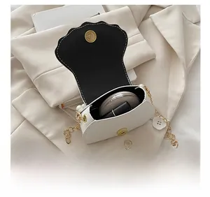 Internal view showing mini shell bag capacity with lipstick and compact powder