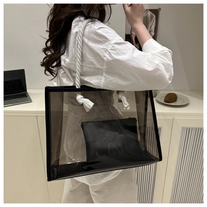 Detail of transparent PVC tote bag with white cotton rope handle and black inner pouch