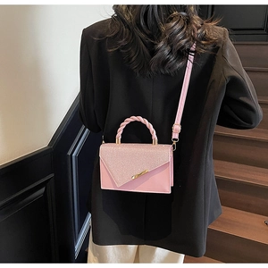 Sac bandoulière rose avec paillettes brillantes, poignée tressée et détail doré