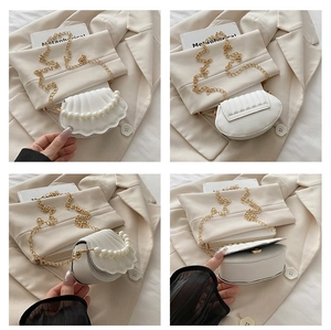 Detail of shell-shaped white crossbody bag with pearl accents and gold chain strap