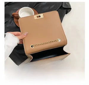 Detail showing the internal storage space and golden chain of the khaki shoulder bag