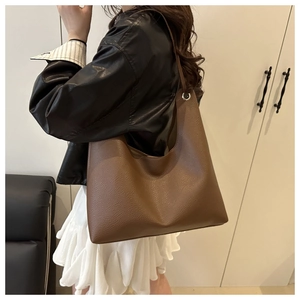 Vue latérale du grand sac hobo en cuir marron montrant sa capacité et ses œillets argentés