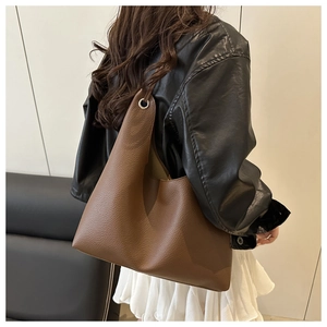 Sac fourre-tout marron avec texture litchi et détails d'œillets sur un modèle décontracté