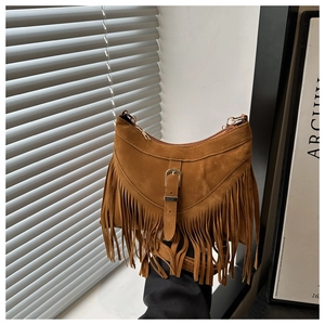 Detail of bohemian brown suede crossbody bag with long tassels and buckle strap