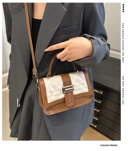 Détail du sac à main bicolore café et crème avec matelassage en losanges et boucle argent