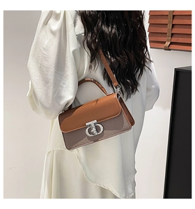 Detail showing the metal buckle and brown leather flap of the vintage crossbody bag