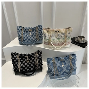 Detail of four denim tote bags with fringe, star patterns and gold deer charms