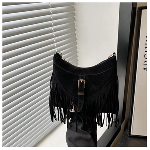 Detail of black suede fringe bag with retro metal buckle and bohemian tassels