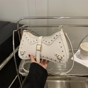 White crocodile-embossed shoulder bag with gold studs and adjustable strap detail