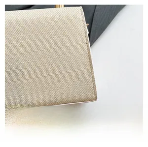 Détail de la texture tissée beige clair avec bordure en cuir blanc sur un sac bandoulière