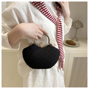 Detail of black rhinestone evening bag with gold metal handle and large crystal clasp
