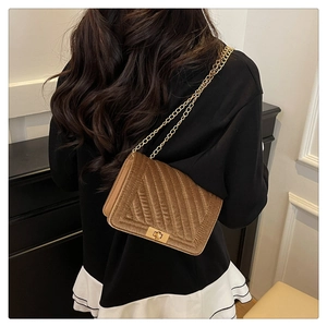 Brown velvet quilted chain bag shown on model highlighting the elegant texture and scale