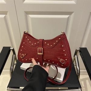 Burgundy crocodile pattern underarm bag with gold rivets and vintage millennial style