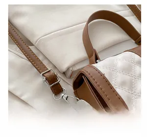 Détail de la bandoulière marron réglable avec boucle en métal argenté sur le sac matelassé