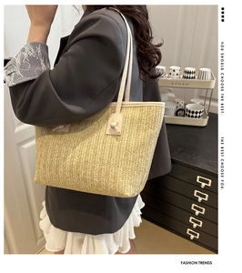 Detail of hand-woven straw tote bag with unique knotted handle on model's shoulder