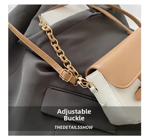 Detail of adjustable metal buckle and contrast stitching on the small shoulder bag