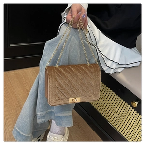 Detail of brown chevron velvet crossbody bag with golden twist lock and chain strap