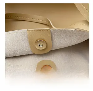 Detailed macro view of magnetic clasp and premium beige leather texture on tote bag