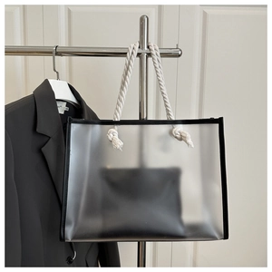 Detail of transparent PVC tote bag with white cotton rope handles and black inner pouch