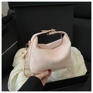 Detail of pink snake-pattern leather pillow bag with metal buckle on black gift box