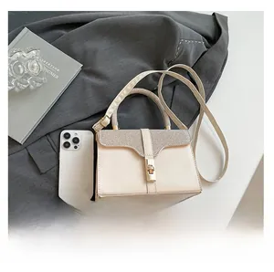 Detail view of small square bag with sparkling flap and phone for size comparison