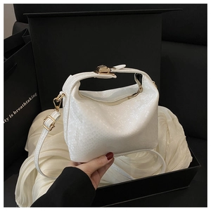 Detail of white crocodile texture handbag in elegant gift box with golden hardware
