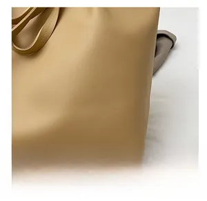 Close-up of beige leather tote bag showcasing premium lychee grain texture and fine stitching